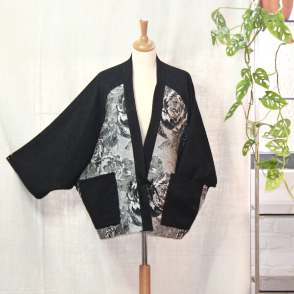 Veste « bi-matières » façon kimono . Jacquard souple noir et empiècements aux motifs de roses dans les coloris noir et argent.