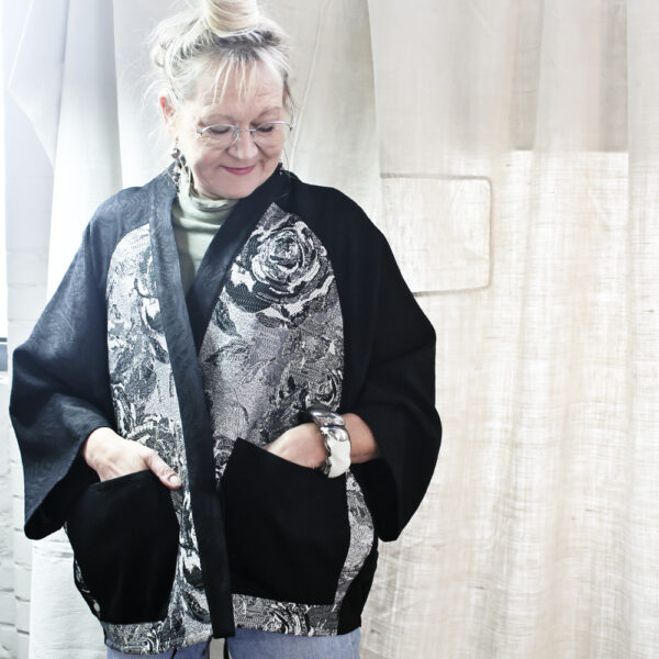 Veste « bi-matières » façon kimono . Jacquard souple noir et empiècements aux motifs de roses dans les coloris noir et argent.