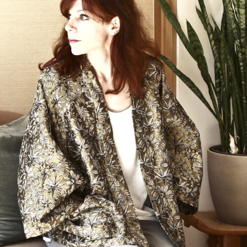 Veste oversize façon kimono. Jacquard motif jungle coloris or. Veste présentée portée