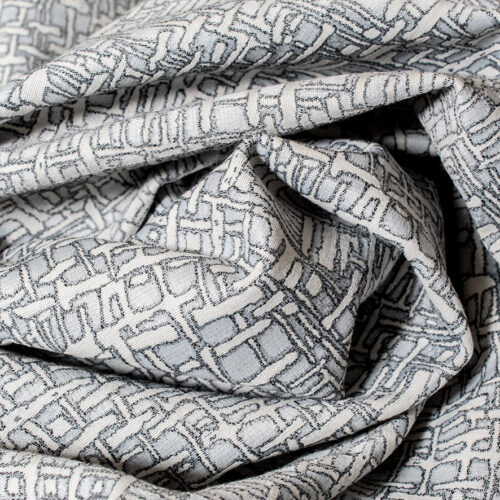 Tissu jacquard double face à micro motifs géométriques gris perle et écru, texture régulière et relief discret.