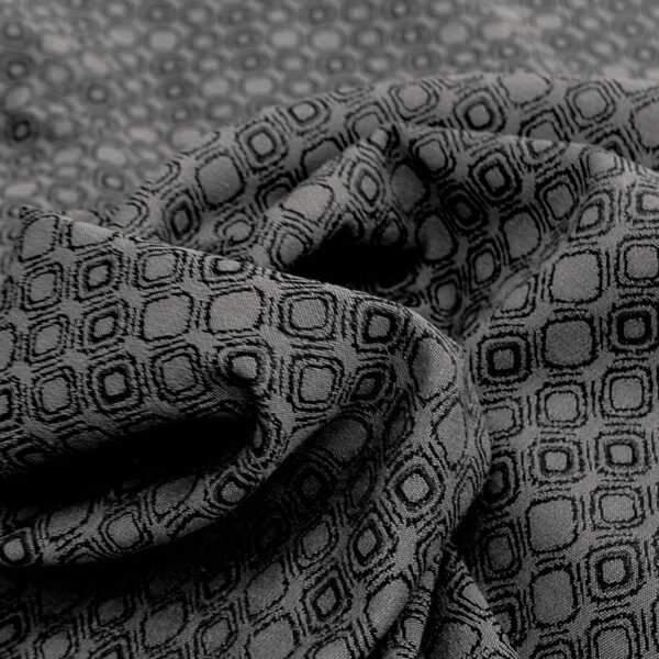 Jacquard double face gris à micro motifs de losanges, surface dense et graphique avec relief régulier.